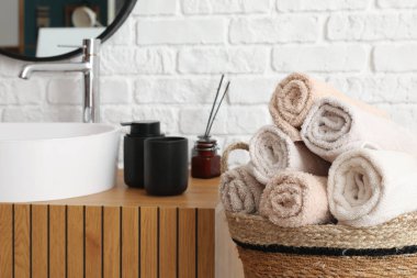 Sepete sarılmış havlular ve lavabo kâsesi ahşap dolapta banyo aksesuarları, yakın çekim