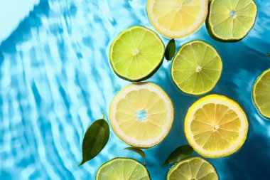 Mavi zemin üzerinde taze limon ve limon dilimleri