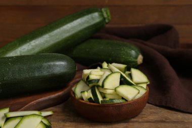 Taze yeşil kabak ve bir kase dilimlenmiş tahta masa.