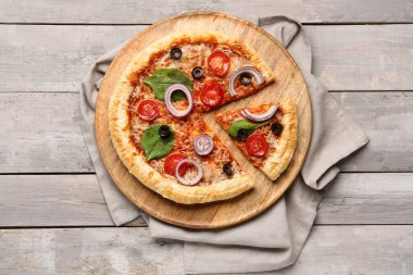 Gri ahşap arka planda fesleğenli ve domatesli lezzetli pizza.