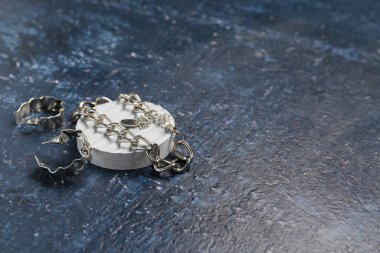 Gümüş küpeli dekoratif podyum ve grunge mavi arka planda kolye