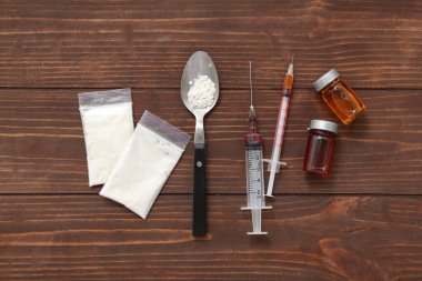 Ahşap zemin üzerinde farklı uyuşturucu ve şırınga bileşimi