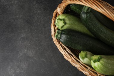 Siyah arka planda taze kabaklı hasır sepet.