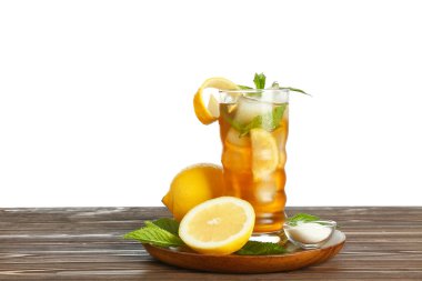 Bir bardak limonlu buzlu çay ve beyaz arka plana karşı ahşap masada nane.