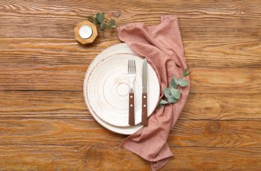 Okaliptüs dalları ve ahşap masa üzerindeki mumlarla güzel bir masa.