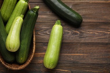 Ahşap arka planda taze yeşil kabaklı hasır kase.