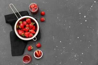 Taze çilekli Colander ve Grunge arka planında tatlı reçel.