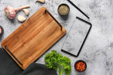 Ahşap mutfak tahtasıyla kompozisyon ve grunge arkaplanda farklı baharatlar