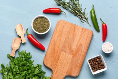 Ahşap kesim tahtası, taze otlar ve renklendirilmiş baharatlar.