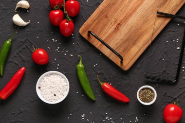 Taze sebzeler, baharatlar ve arka planda ahşap mutfak tahtasıyla kompozisyon.