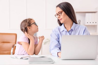 Ofiste küçük kızıyla çalışan bir anne.