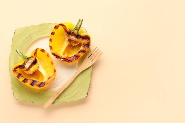 Bej arka planda yarım tabak ızgara dolmalık biber.