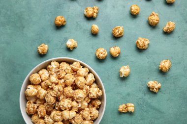 Yeşil arka planda lezzetli patlamış mısırlı kase