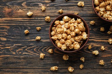 Tahta arka planda lezzetli patlamış mısır kaseleri