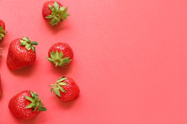 Kırmızı arka planda taze çilekler.