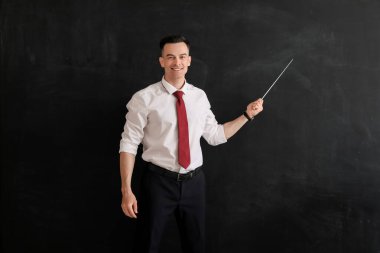 Sınıfta tahtaya yakın duran erkek öğretmen.