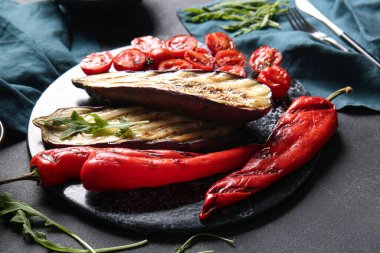 Siyah arka planda lezzetli ızgara sebzeli pano.