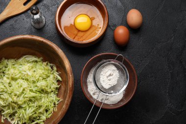 Siyah arka planda kabak böreği hazırlamak için malzemelerle dolu kaseler