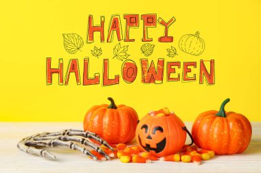 Süslemeli Cadılar Bayramı kartı ve sarı arka planda mısır şekeri.