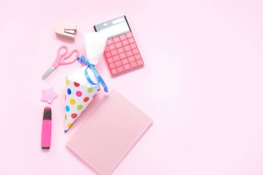 Pembe arka planda farklı kırtasiye malzemesi olan beyaz okul konisi