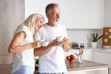 Mutfakta kahve içen olgun bir çift.