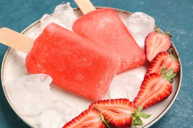 Turkuaz grunge arka planda çilekli dondurma, taze böğürtlen ve buz küpleri.