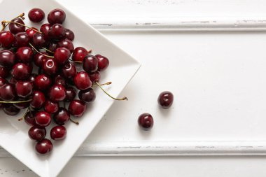 Beyaz arka planda tatlı kirazlı tabak