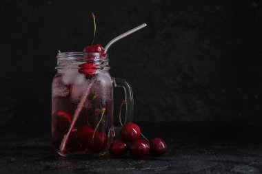 Mason kavanozu siyah arka planda vişneli limonata