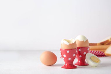 Beyaz arka planda haşlanmış tavuk yumurtası olan tutucular