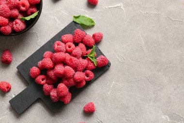 Gri masada taze ahududu tabağı ve yemek.