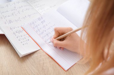 Tahta masaya matematik formülleri yazan bir kadın.