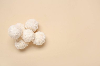 Bej arka planda hindistan cevizi soslu lezzetli beyaz çikolata şekerlemeleri.