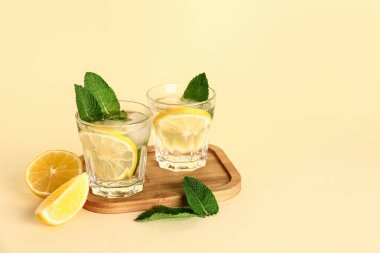 Arkaplanda soğuk mojito, limon ve nane içeren ahşap bir tahta.