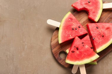 Kahverengi arka planda tatlı karpuz çubukları olan ahşap tahta.