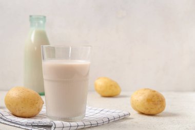 Hafif arka planda bir bardak lezzetli patates sütü.