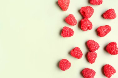 Açık yeşil arka planda bir sürü taze ahududu