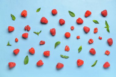 Mavi arka planda bir sürü taze ahududu ve nane