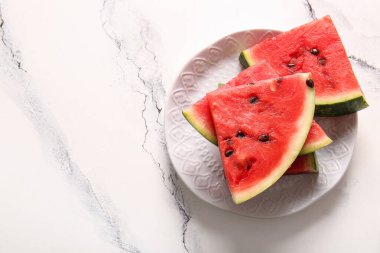 Tabak beyaz masada taze karpuz parçaları.