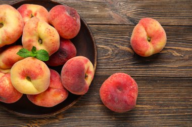 Tatlı incir şeftalili tabak ve ahşap zemin üzerinde nane.