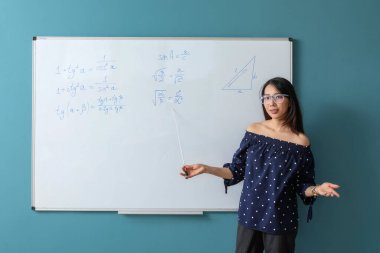 Sınıfta yazı tahtasının yanında Asya Matematik öğretmeni