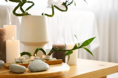 Kaplıca salonundaki masada taş ve bambuyla yanan mumlar, yakın plan.