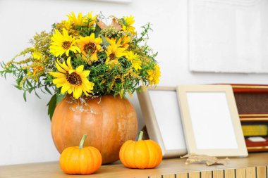 Sonbahar buketli balkabakları ve raflarda boş çerçeveler.