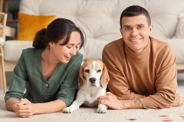 Evde sevimli Beagle köpeği olan genç bir çift.