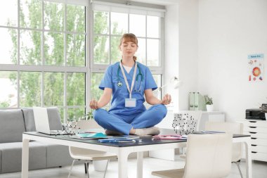Klinikteki masada meditasyon yapan kadın stajyer.