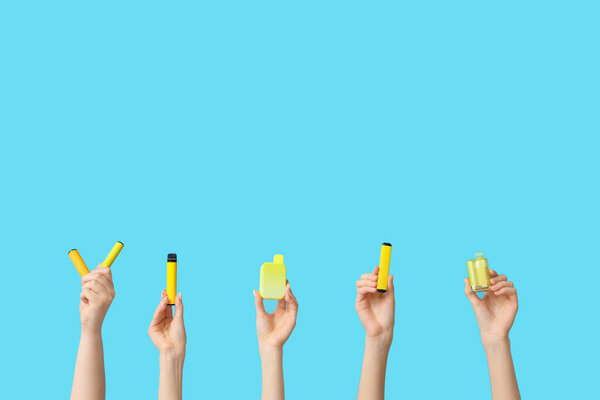 Многие руки держат электронные сигареты на синем фоне