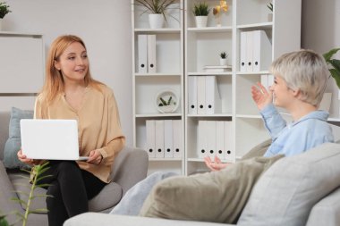 Ofiste genç bir kızla konuşan kadın psikolog.