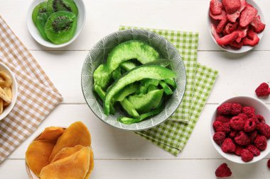 Beyaz ahşap arka planda farklı susuz meyve ve meyveler.