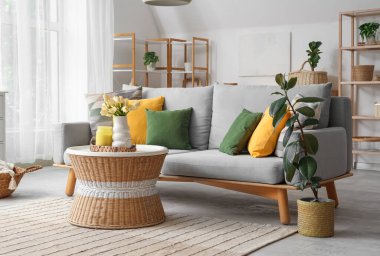 Koltuk, tencere sehpası ve çiçekli hafif konforlu oturma odası.