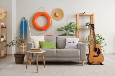 Kanepesi, gitarı ve can simidi olan modern oturma odasının içinde.