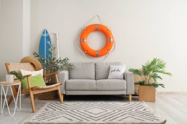 Oturma odasında rahat bir kanepe, koltuk ve can simidi.